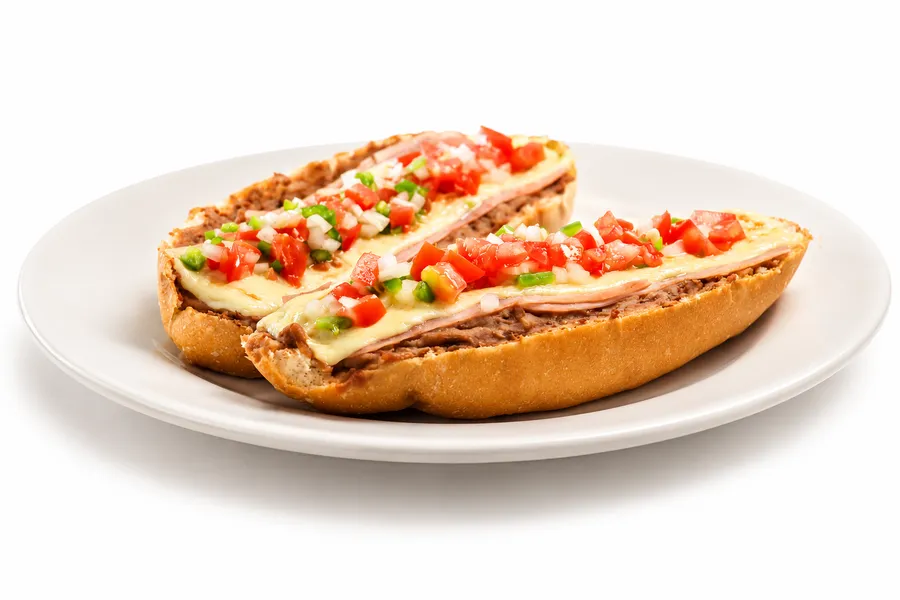 Molletes Tradicionales (2 pzs.) — Frijol refrito, jamón, queso gratinado y pico de gallo.